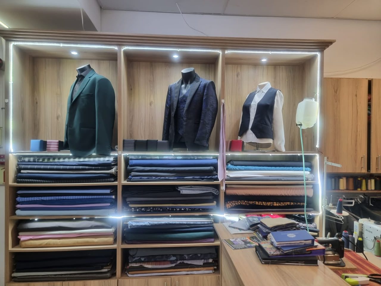 Fabric wall of imported Italian suiting with tailored jackets and a ladies waistcoat on display